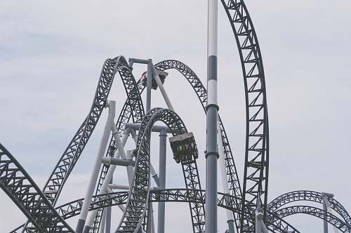 grey roller coaster under white clouds and blue sky roller coaster